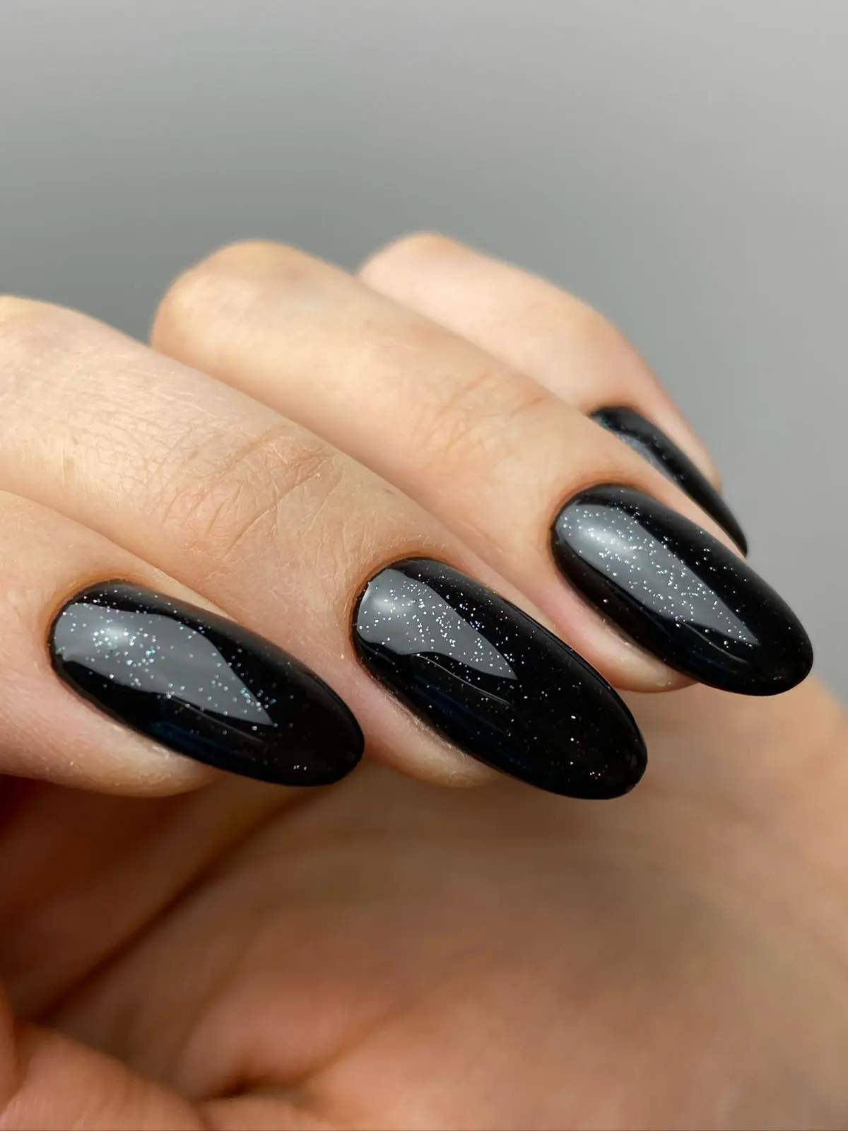Czarny manicure hybrydowy z brokatowym wykończeniem na paznokciach w kształcie migdałków – Nails by Korzeniowska, Ursynów, Warszawa