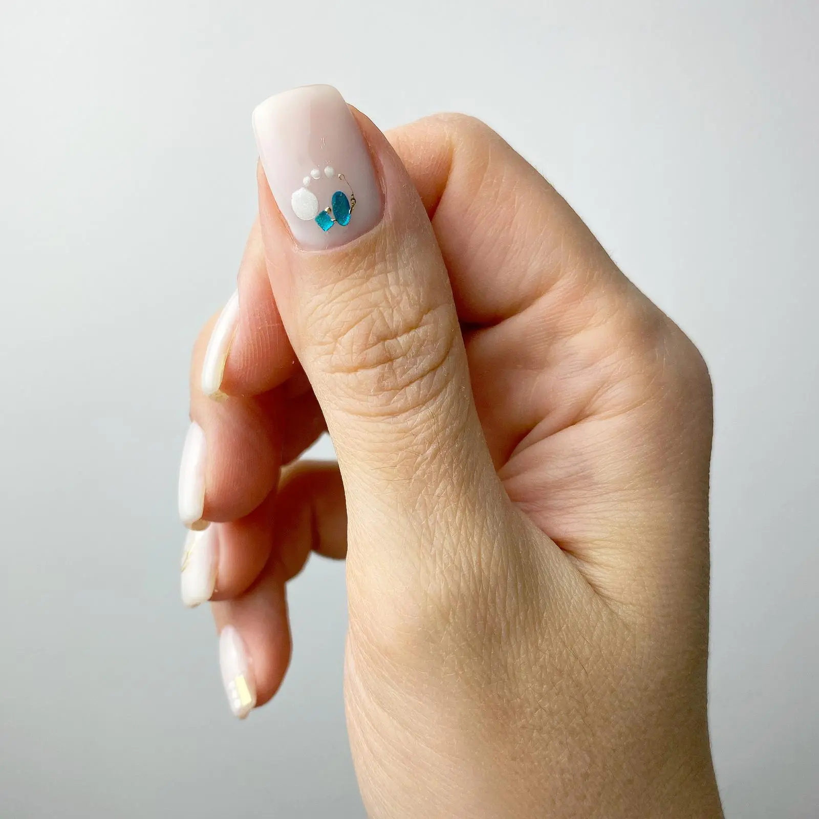 Manicure hybrydowy w odcieniu nude na krótkich, kwadratowych paznokciach ze zdobieniem z płatków – Nails by Korzeniowska, Ursynów, Warszawa